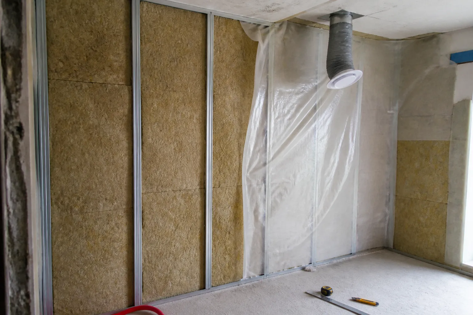 Pose d’un doublage isolant sur ossature contre un mur intérieur de logement