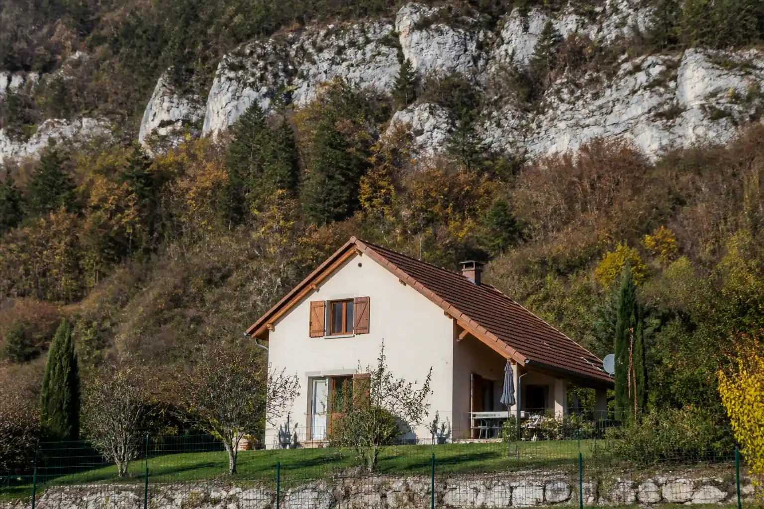Maison individuelle de piémont adossée au relief du Vercors, façade enduite claire