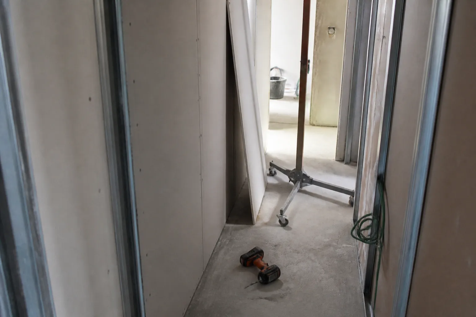 Plaques de plâtre stockées debout le long d’un couloir d’appartement en chantier